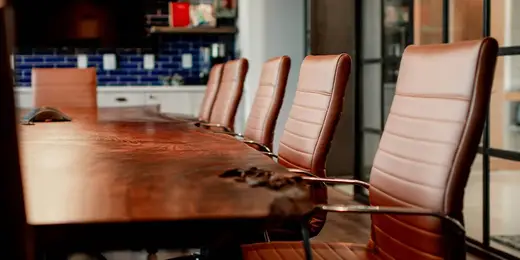 An empty conference room with a live-edge wood table and leather chairs, where a mineral rights search is scoped before the records work begins